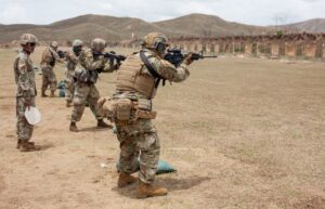 A group of soldiers are practicing shooting at an obstacle course.