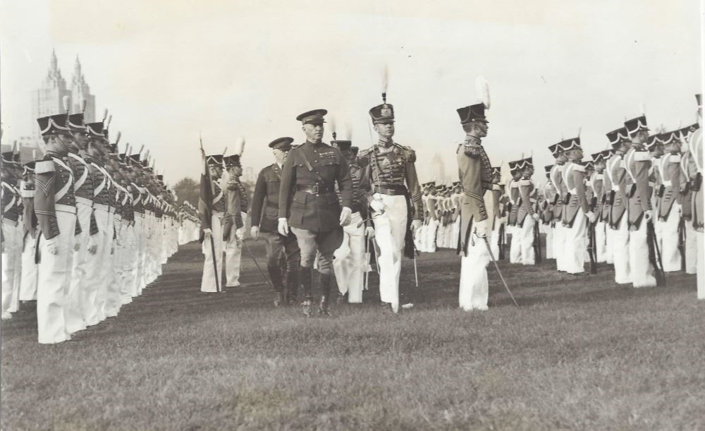 A group of men in uniforms marching on grass.